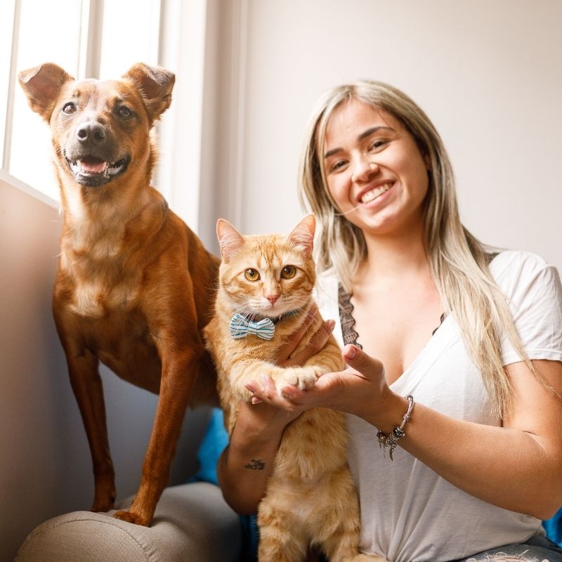 Woman, dog, and cat smiling