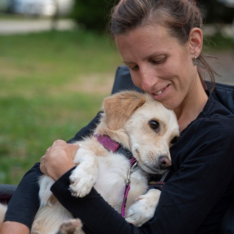 Woman hugging cute puppy.
